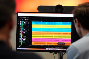 Waveforms of audio files from various instruments are displayed during the creation of an AI musical piece at SUNO