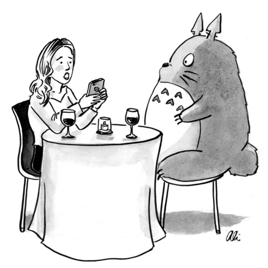 A woman sits across a caf table from Totoro.