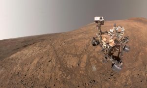 NASA's Perseverance took this selfie on May 10, 2025. The small puff of dust left of center and below the horizon line is a dust devil.
