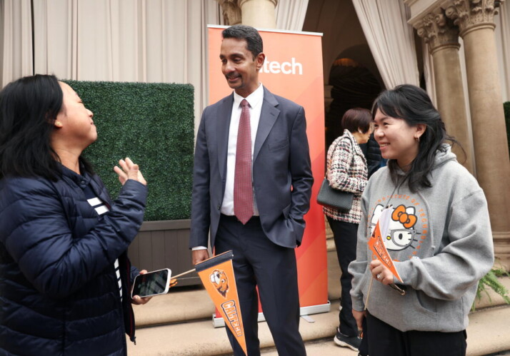 A woman talks to a man as another woman looks on next to him.