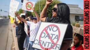 Demonstrators wave signs during a nationwide protest against AI data center expansion.